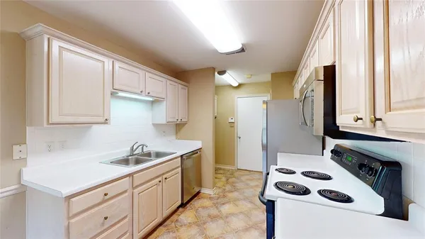 a kitchen with granite countertop a sink and a refrigerator