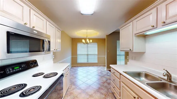 a kitchen with a sink a stove and cabinets