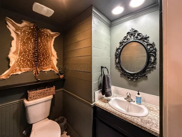 a bathroom with a granite countertop toilet sink and mirror