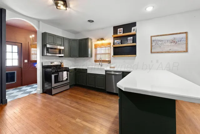 a kitchen with stainless steel appliances kitchen island granite countertop a sink and a stove