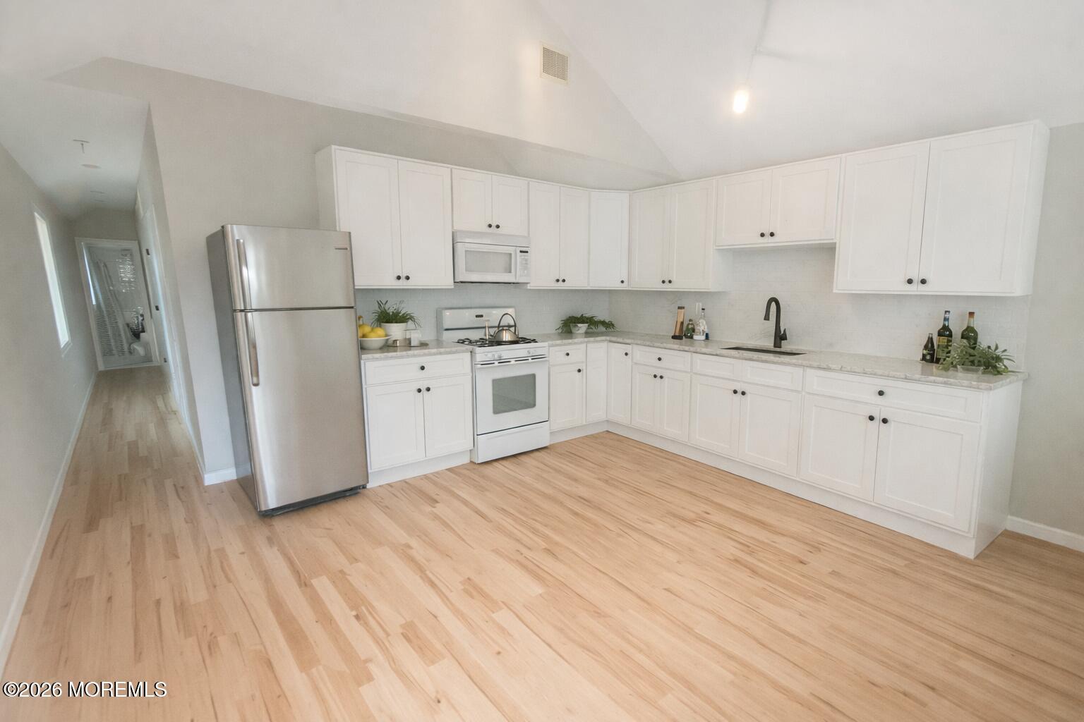 98 Raritan Avenue Keansburg, NJ 07734 - Photo 4 of 4 a large kitchen with a white wooden cabinets and wooden floor