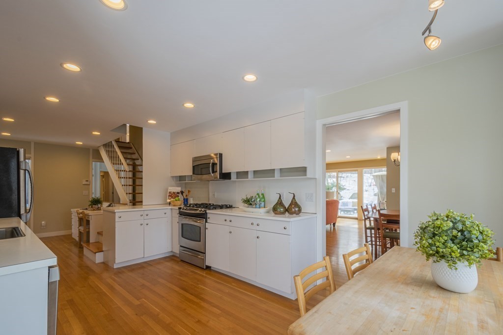43 Baskin Road Lexington, MA 02421 - Photo 13 of 42 a kitchen with a sink dishwasher stove and white cabinets with wooden floor