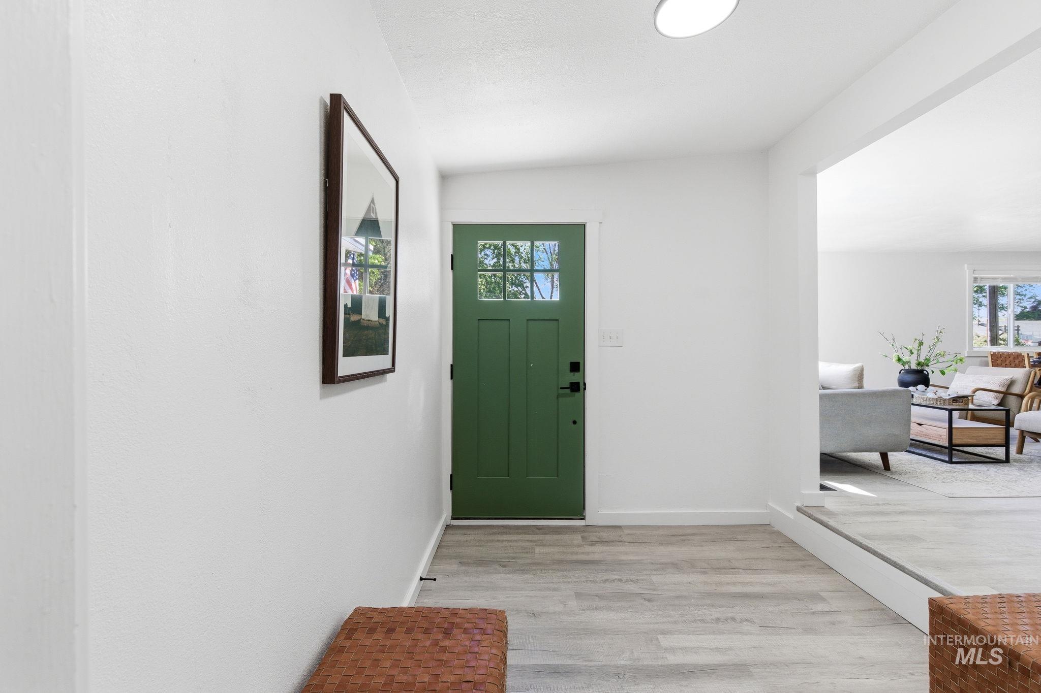 2224 Rachel Circle Boise, ID 83706 - Photo 6 of 50 Entryway featuring a green front door with clear glass panes, wood-finish flooring, and crisp white walls