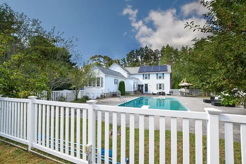 a view of a house with a small yard and wooden fence