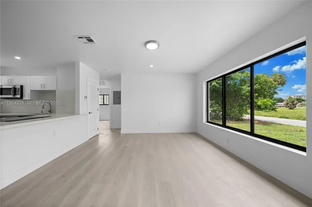 a large kitchen with a large window and stainless steel appliances