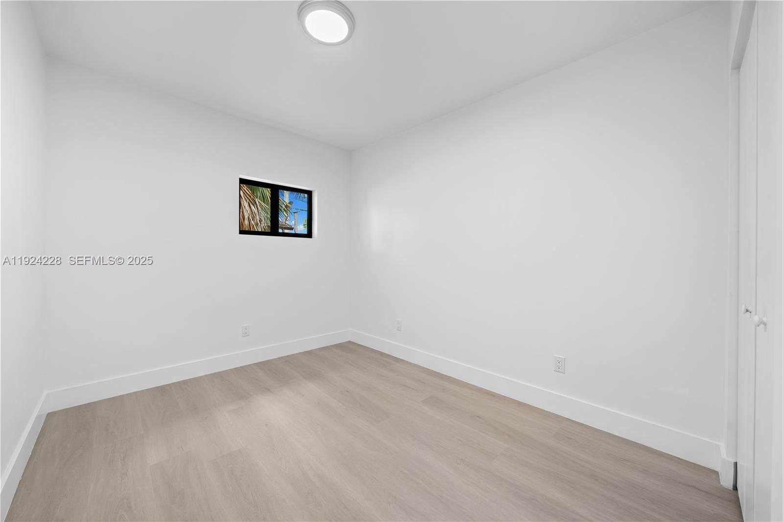 2983 Northwest 1st Street Pompano Beach, FL 33069 - Photo 11 of 28 a view of a room with a wooden floor and window
