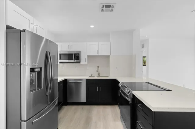 a kitchen with stainless steel appliances granite countertop a sink stove and refrigerator