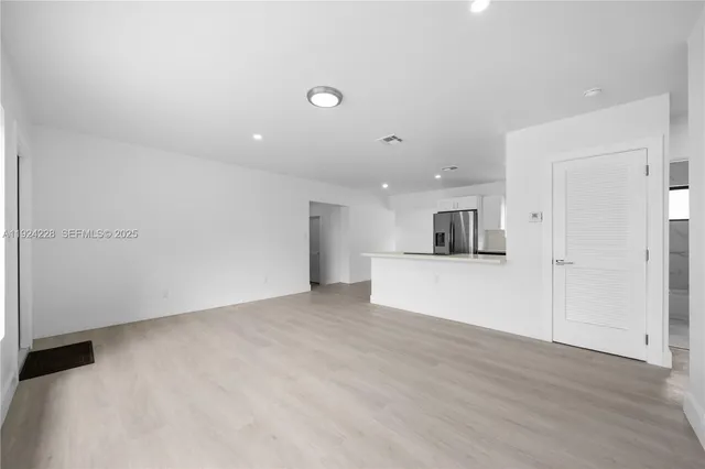 a kitchen with stainless steel appliances granite countertop a refrigerator a sink a stove and white cabinets