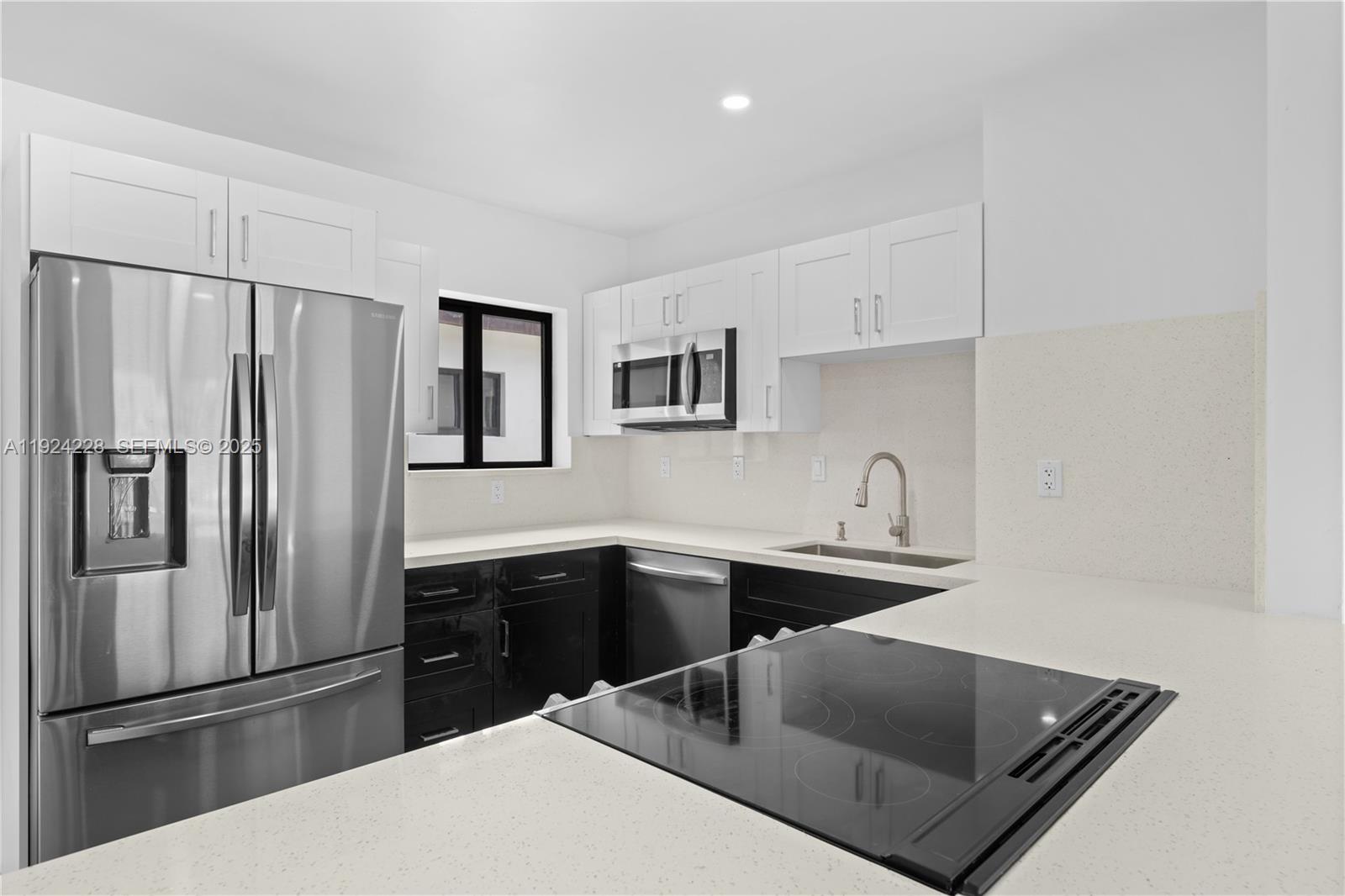 2983 Northwest 1st Street Pompano Beach, FL 33069 - Photo 20 of 28 a kitchen with stainless steel appliances granite countertop a refrigerator a sink a stove and white cabinets