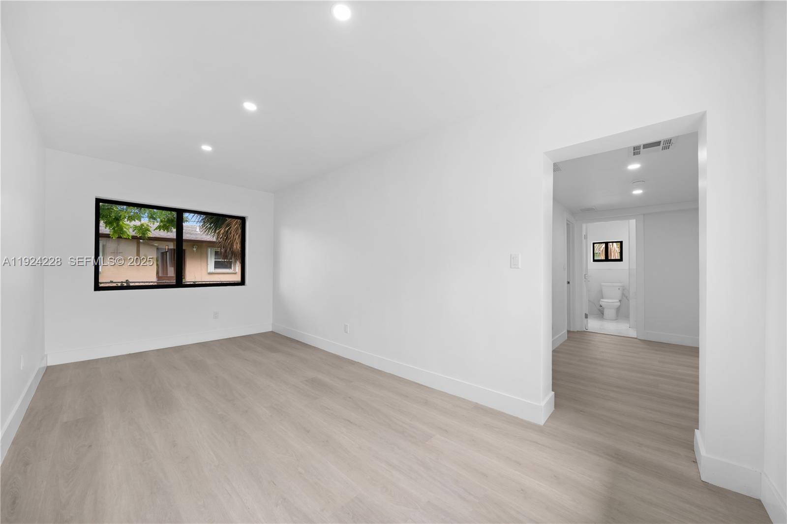 2983 Northwest 1st Street Pompano Beach, FL 33069 - Photo 24 of 28 an empty room with wooden floor and windows