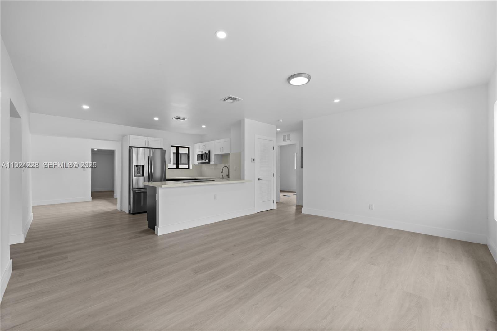2983 Northwest 1st Street Pompano Beach, FL 33069 - Photo 25 of 28 a view of kitchen with refrigerator and white cabinets
