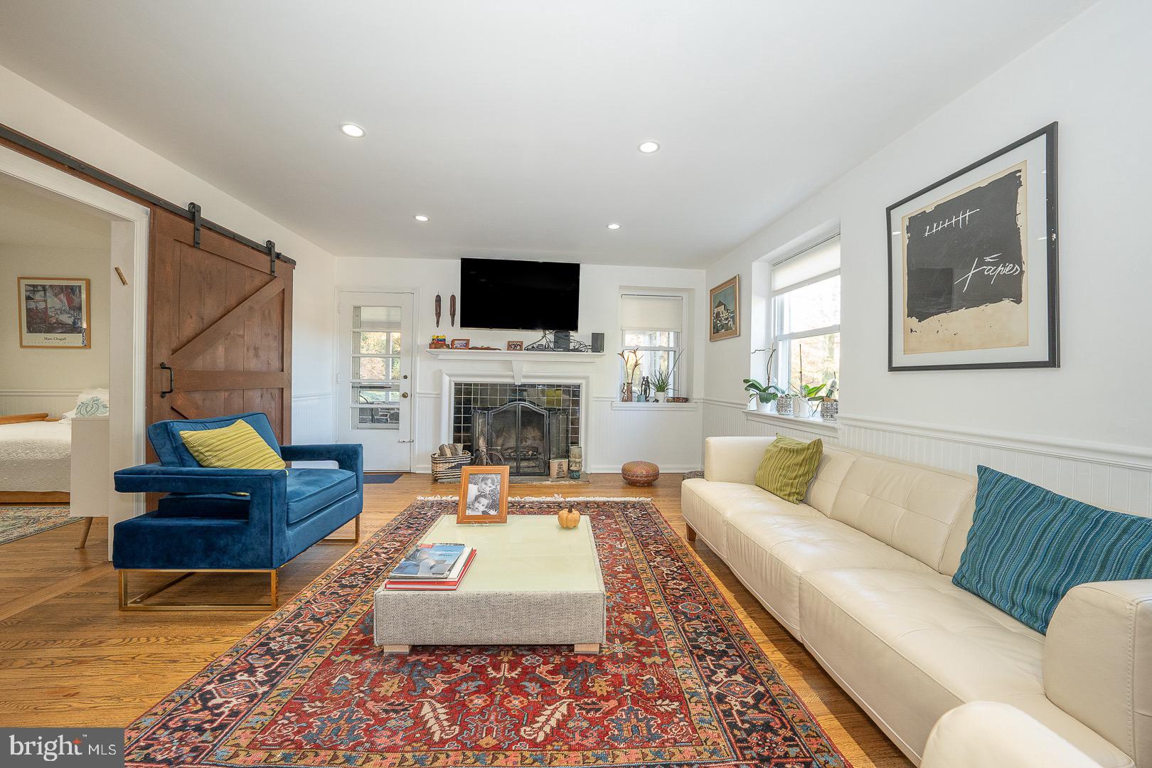 401 North Spring Mill Road Villanova, PA 19085 - Photo 12 of 76 a living room with furniture a rug a fireplace and a flat screen tv