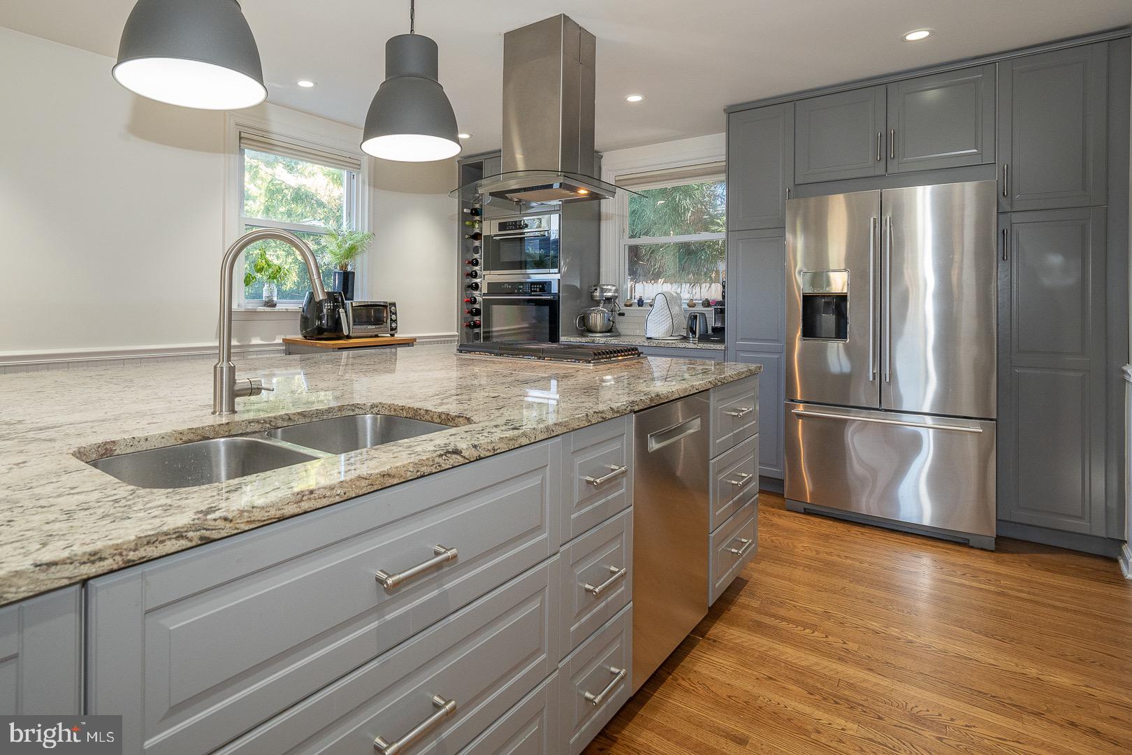 401 North Spring Mill Road Villanova, PA 19085 - Photo 30 of 76 a kitchen with stainless steel appliances granite countertop a sink a refrigerator and a wooden floor