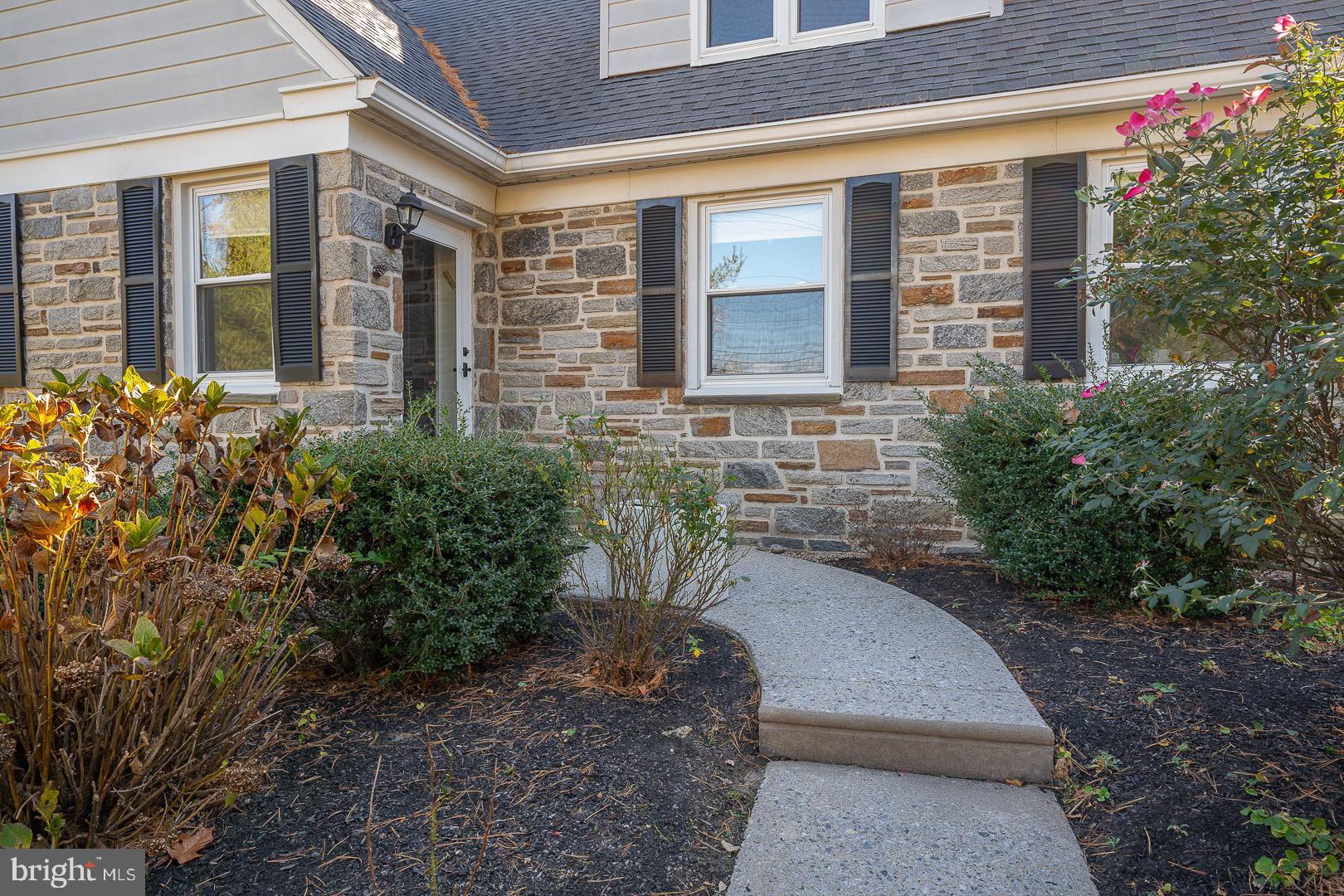 401 North Spring Mill Road Villanova, PA 19085 - Photo 6 of 76 a view of a brick house with many windows plants and large trees