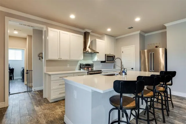 a kitchen with a dining table chairs refrigerator and cabinets