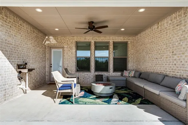 a living room with furniture ceiling fan and a flat screen tv