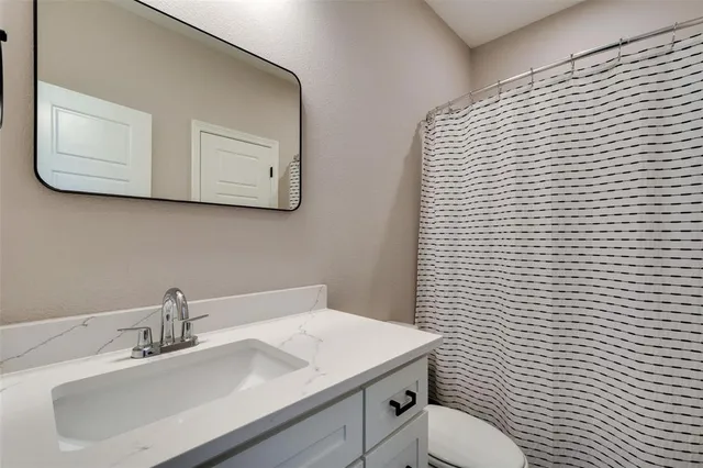 a bathroom with a sink a toilet and mirror