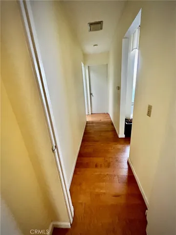 a view of a hallway with wooden floor and stairs