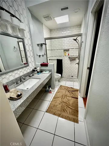 a bathroom with a sink mirror and shower