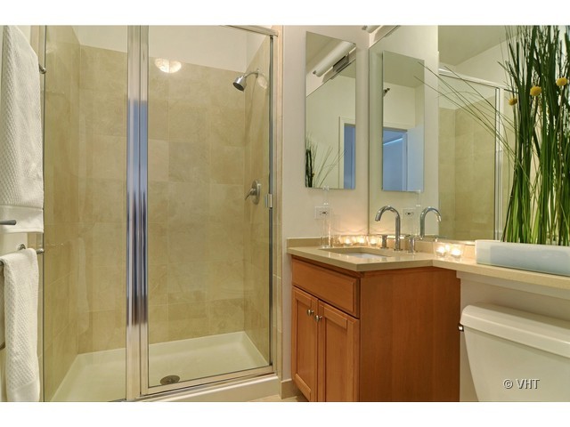 501 North Clinton Street, Unit 1105 Chicago, IL 60654 - Photo 14 of 15 a bathroom with a granite countertop sink a mirror and shower