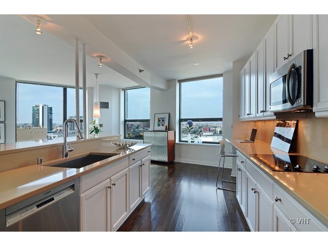 501 North Clinton Street, Unit 1105 Chicago, IL 60654 - Photo 7 of 15 a kitchen with wooden floor and stainless steel appliances