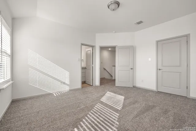 an empty room with windows and closet