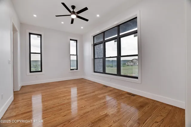 a view of empty room with wooden floor