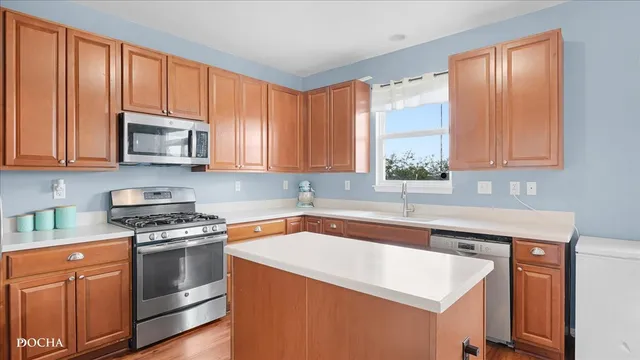 a kitchen with stainless steel appliances granite countertop a sink stove and microwave
