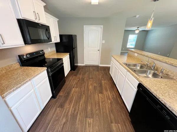 a kitchen with a sink a microwave oven a stove and refrigerator