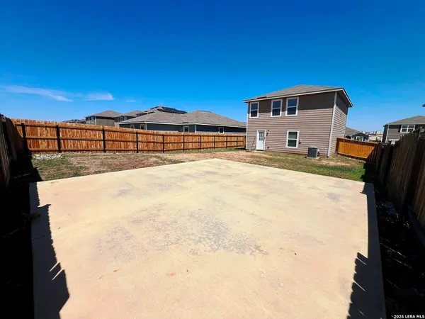 a view of an house with backyard and a tree