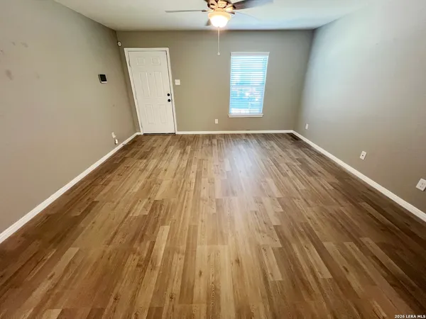 a view of a room with wooden floor and window