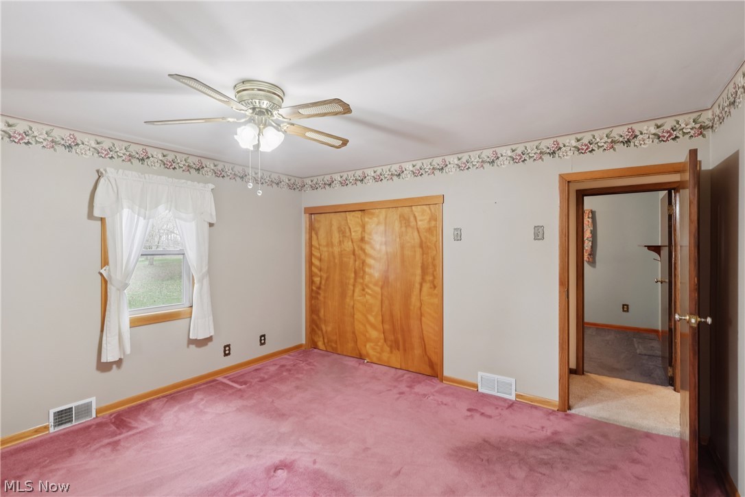 402 Yager Road Clinton, OH 44216 - Photo 21 of 38 Primary bedroom with double closet, ceiling fan / light, and carpet flooring