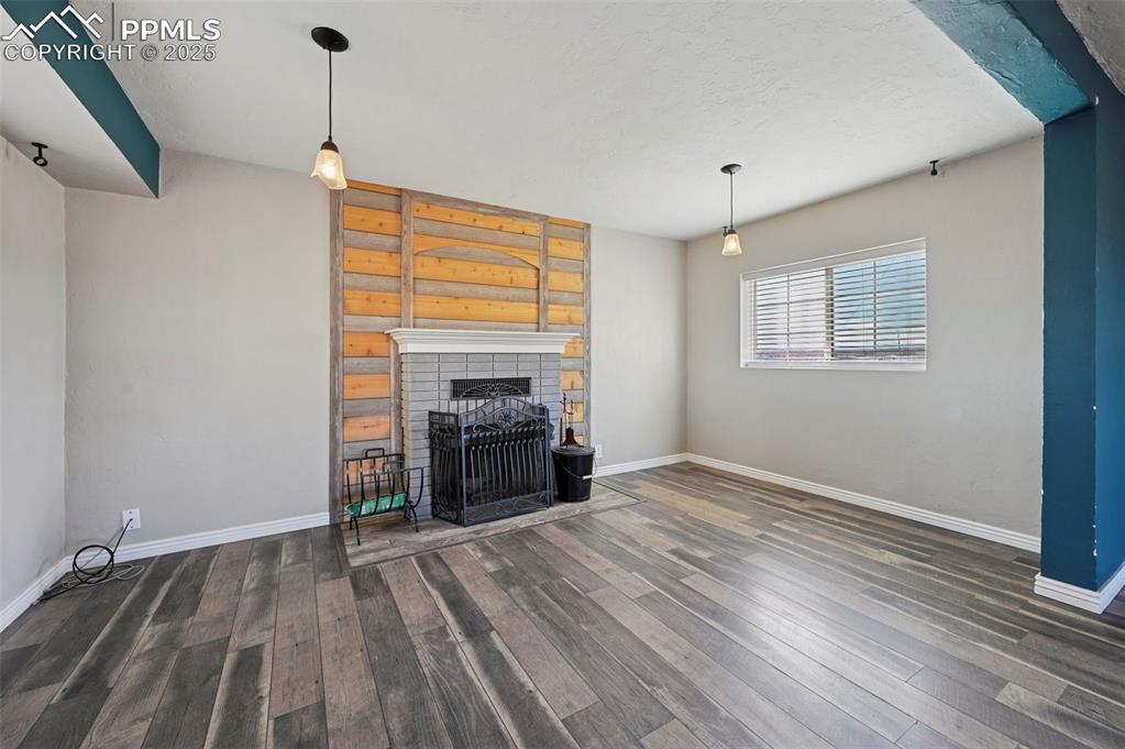 7865 Wilson Road Fountain, CO 80817 - Photo 11 of 46 a view of empty room with a fireplace and wooden floor
