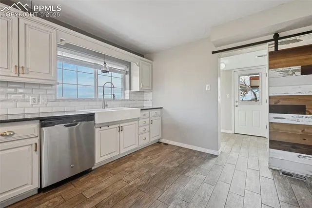 a kitchen with a sink cabinets and wooden floor