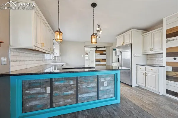 a kitchen with stainless steel appliances granite countertop a sink a stove and cabinets