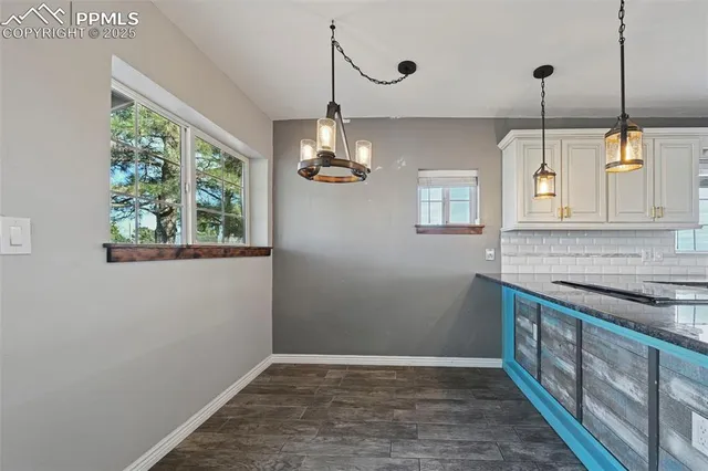 a kitchen with stainless steel appliances granite countertop cabinets a sink a window and a wooden floor