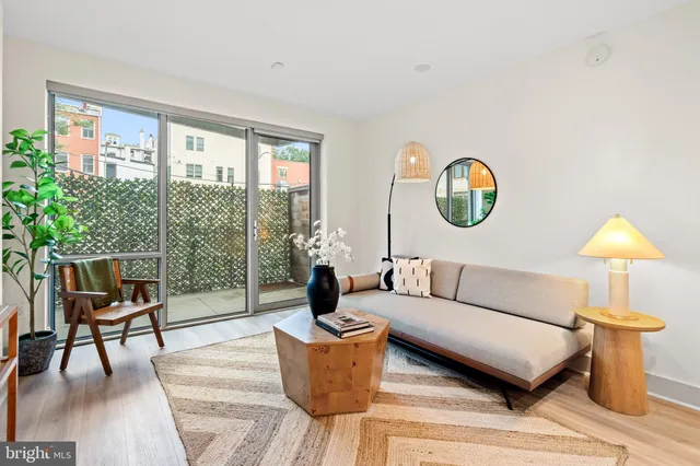 a living room with furniture a table and a large window