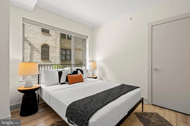 a bedroom with a bed and a large window