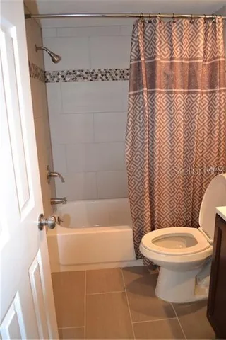 a white toilet sitting next to a bath tub