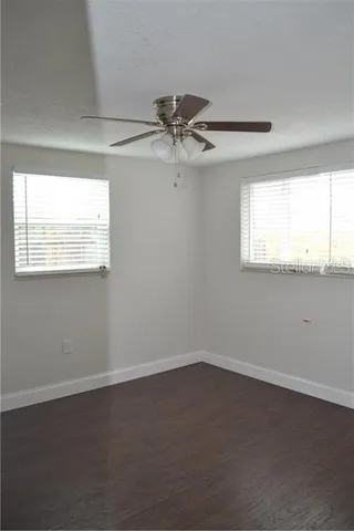an empty room with a window and a ceiling fan
