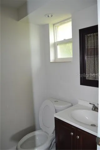a bathroom with a toilet a sink and mirror