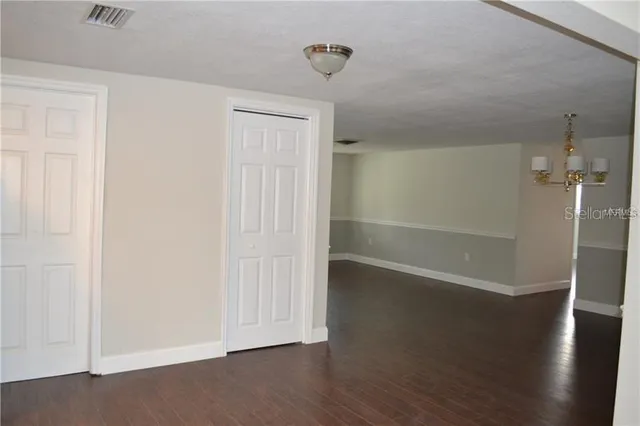 an empty room with wooden floor and closet