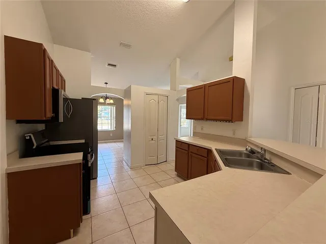 a kitchen with stainless steel appliances a stove a microwave a sink and a refrigerator