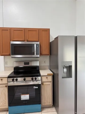 a kitchen with a refrigerator sink and wooden cabinets