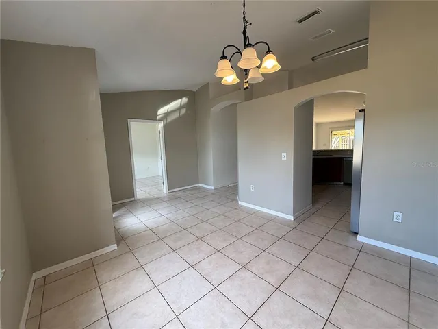 an empty room with mirror and tiles