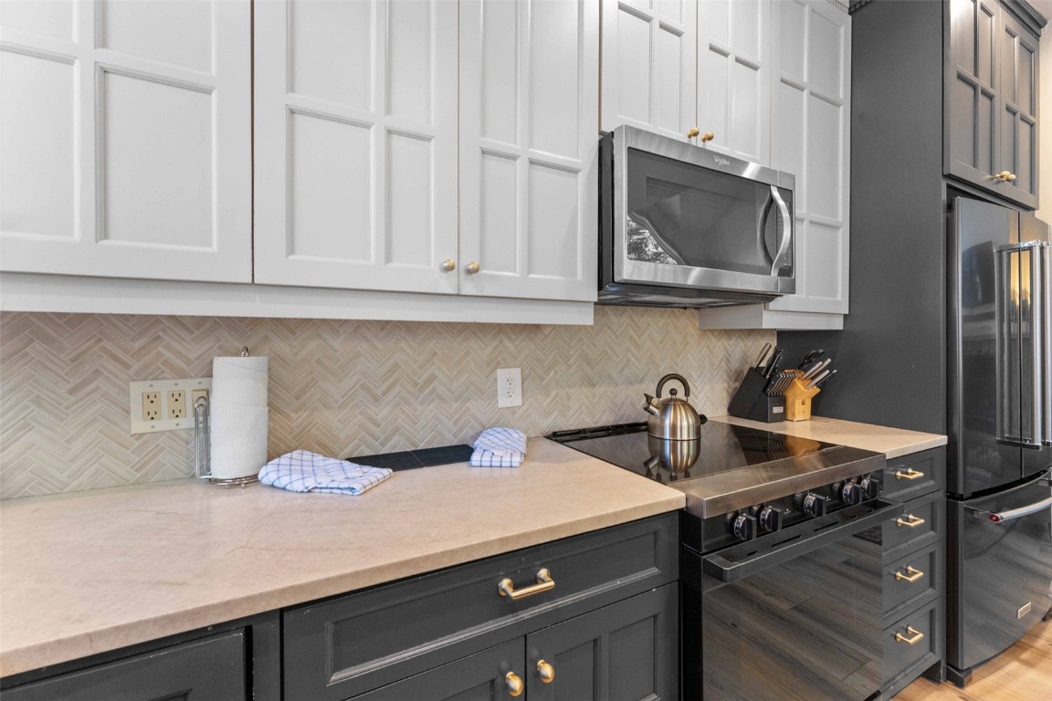 1459 East Keystone Road, Unit C1 Dillon, CO 80435 - Photo 8 of 27 Kitchen featuring white cabinetry, light stone countertops, tasteful backsplash, light hardwood / wood-style floors, and appliances with stainless steel finishes