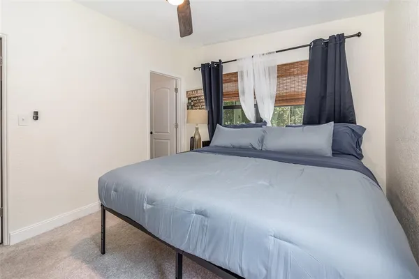 a large bed sitting in a bedroom next to a window