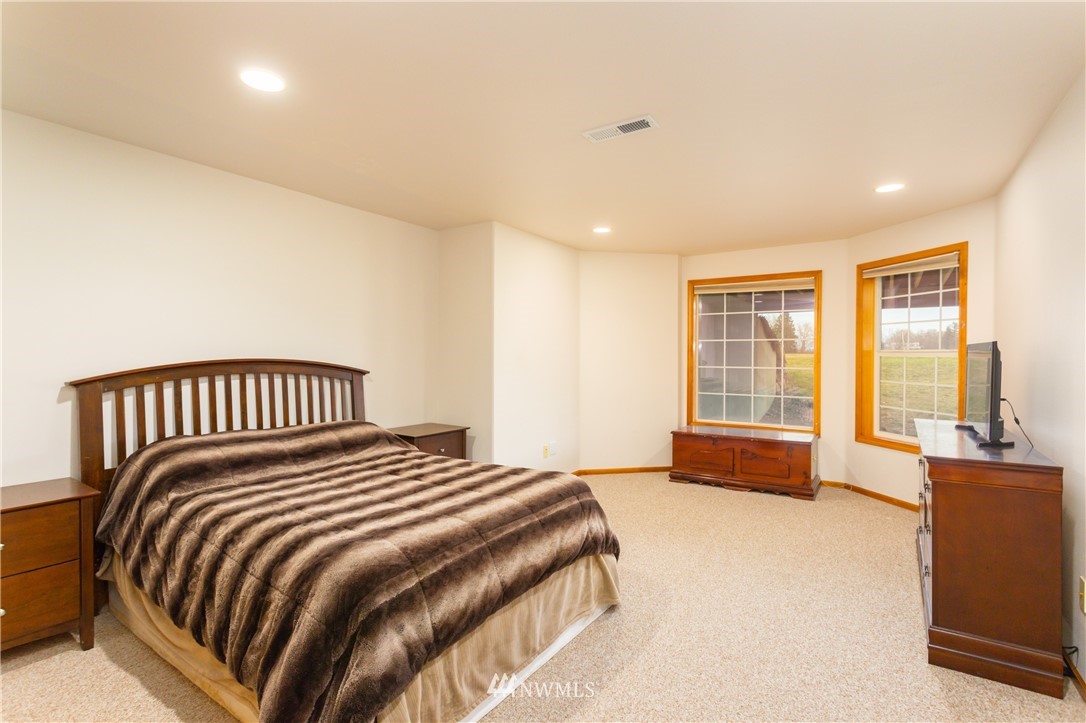 8416 Delta Line Road Custer, WA 98240 - Photo 20 of 40 a bedroom with a bed and glass windows