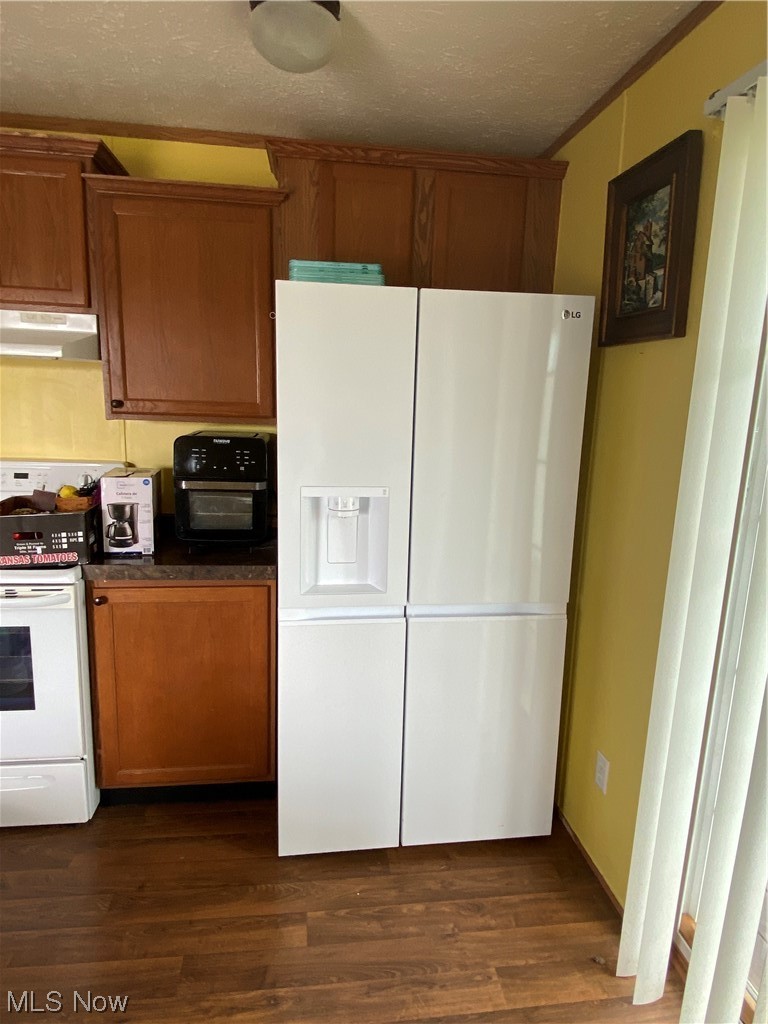 85 Rains Circle Zanesville, OH 43701 - Photo 6 of 15 Kitchen featuring white refrigerator with ice dispenser, dark hardwood / wood-style floors, a textured ceiling, stove, and range hood