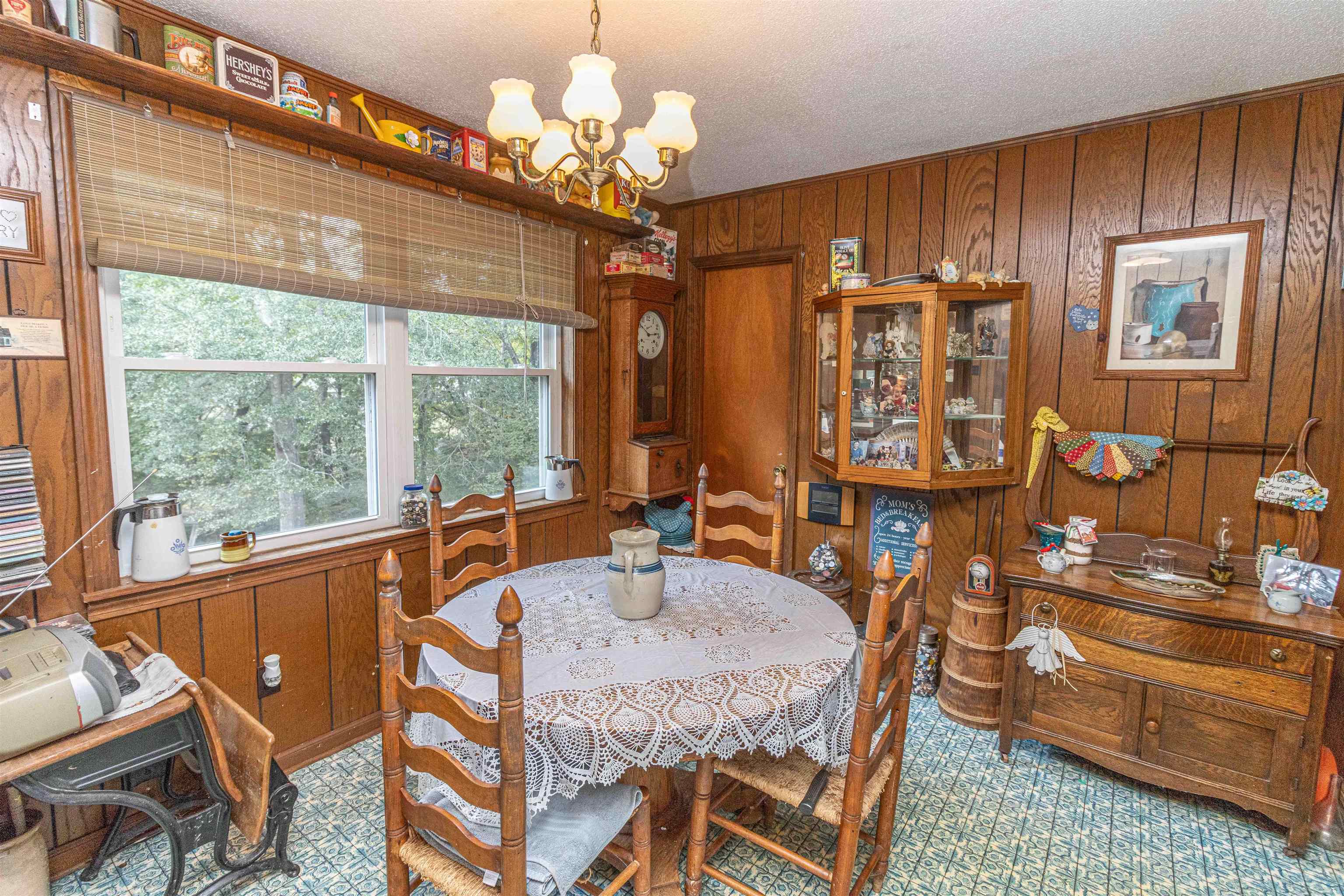 260 Mitchell Street Selmer, TN 38375 - Photo 9 of 22 a dining room with wooden floor a chandelier a wooden table and chairs